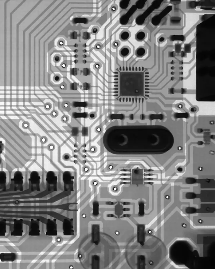 Monochrome macro photograph of a printed circuit board and its conductive traces.