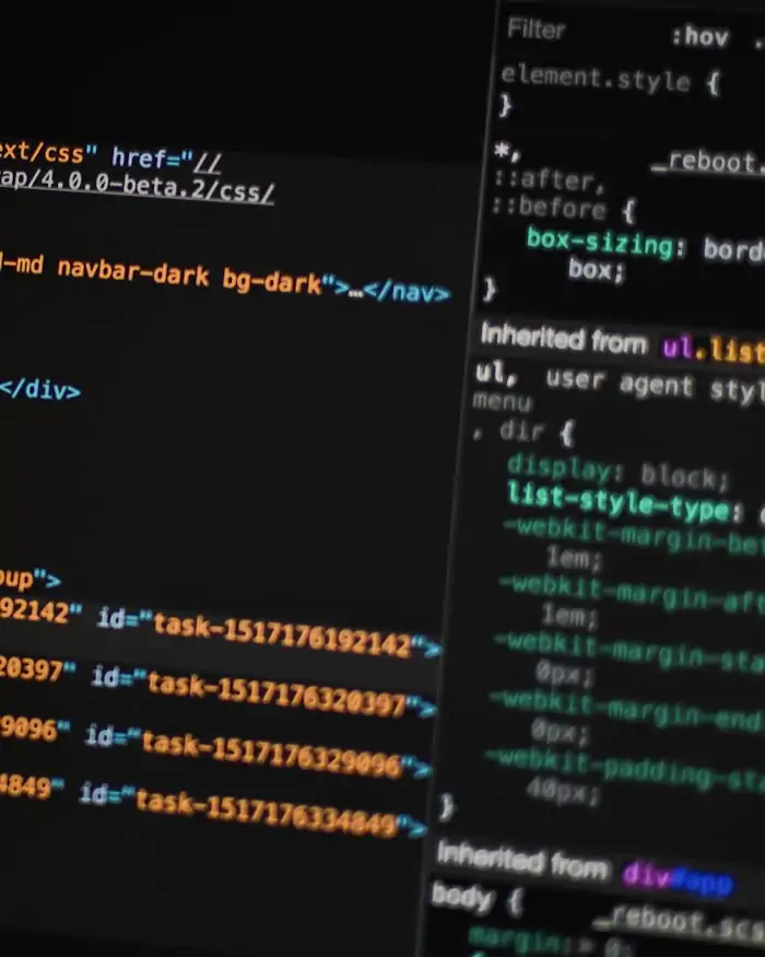 Program code displayed on a dark monitor, shallow focus.